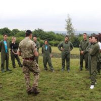 Two of the teams reciving a debrief after a leadership challenge