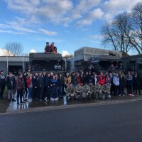 The students and reservists in front of Army HGVs