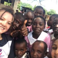 Cadet Evie Botting with schoolchildren in Africa