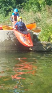 A kayak tips into the water off the side