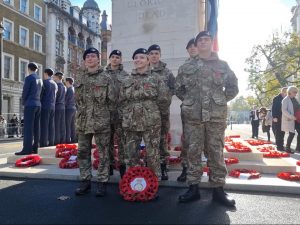 Six cadets in front of the Cenotaph in London with a poppy wreath in front of them.