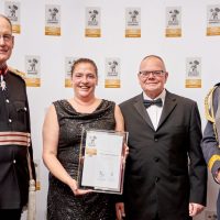 Four people stood together. One holds a certificate.