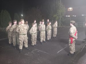 16 Army Cadets on parade in a car park.