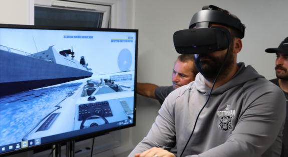 Nottingham Panthers Head Coach Jonathan Paredes operates a powerboat on HMS Sherwood's virtual reality simulator.